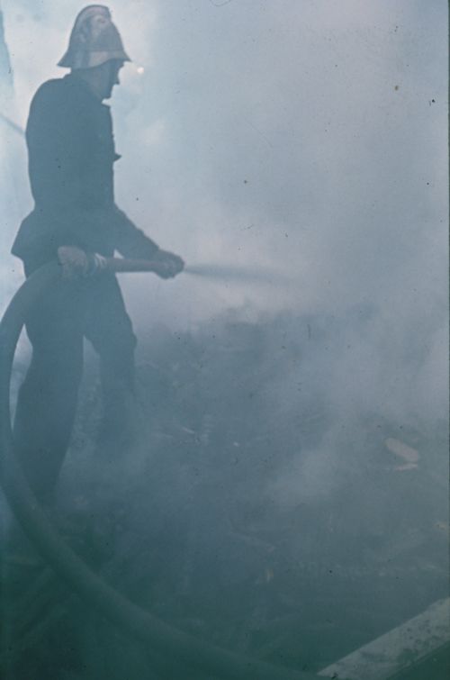 Fotografie, Liestal, Feuerwehrmann beim Brand der Sägemühle