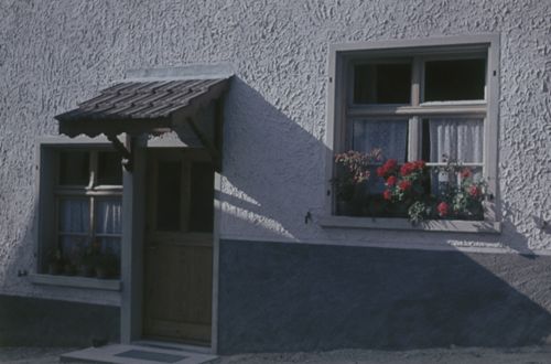 Fotografie, Hauseingang und Fenster mit Blumen